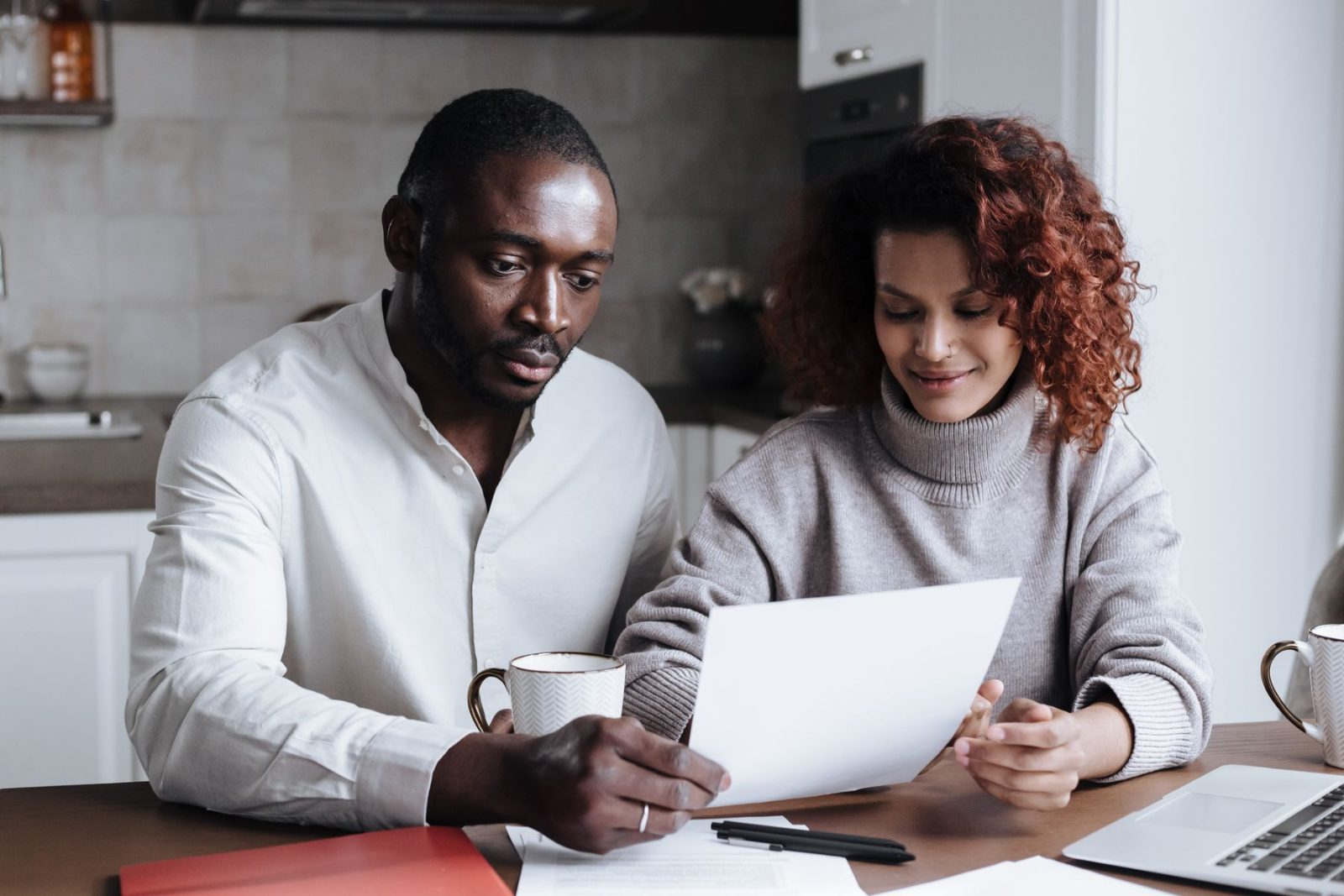 Couple reviewing mortgage paperwork together at their kitchen table